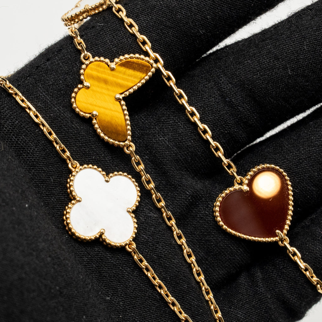 VAN CLEEF & ARPELS LUCKY ALHAMBRA LONG NECKLACE, 12 MOTIFS, YELLOW GOLD, CARNELIAN, MALACHITE, WHITE AND GREY MOTHER-OF-PEARL, TIGER EYE