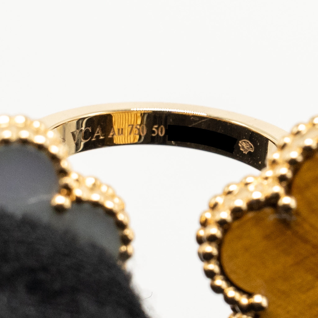 VAN CLEEF & ARPELS LUCKY ALHAMBRA BETWEEN THE FINGER RING, YELLOW GOLD, WHITE MOTHER-OF-PEARL, TIGER’S EYE